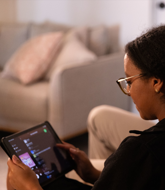 Woman on couch looking at computer tablet