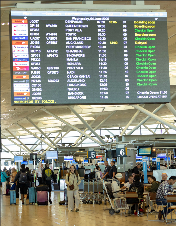 departures board and crowd inside international airport terminal