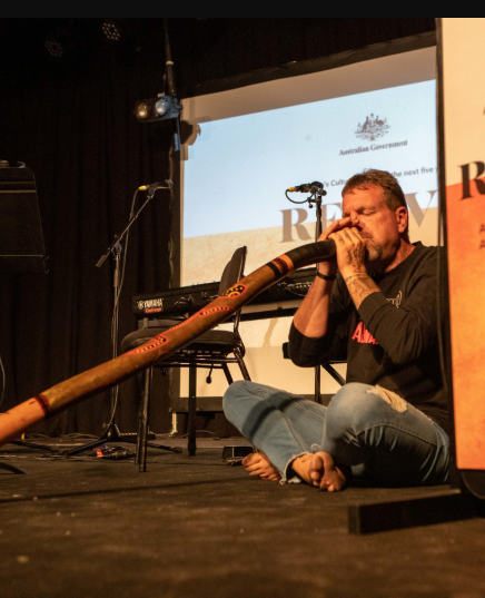 Man playing didgeridoo on stage