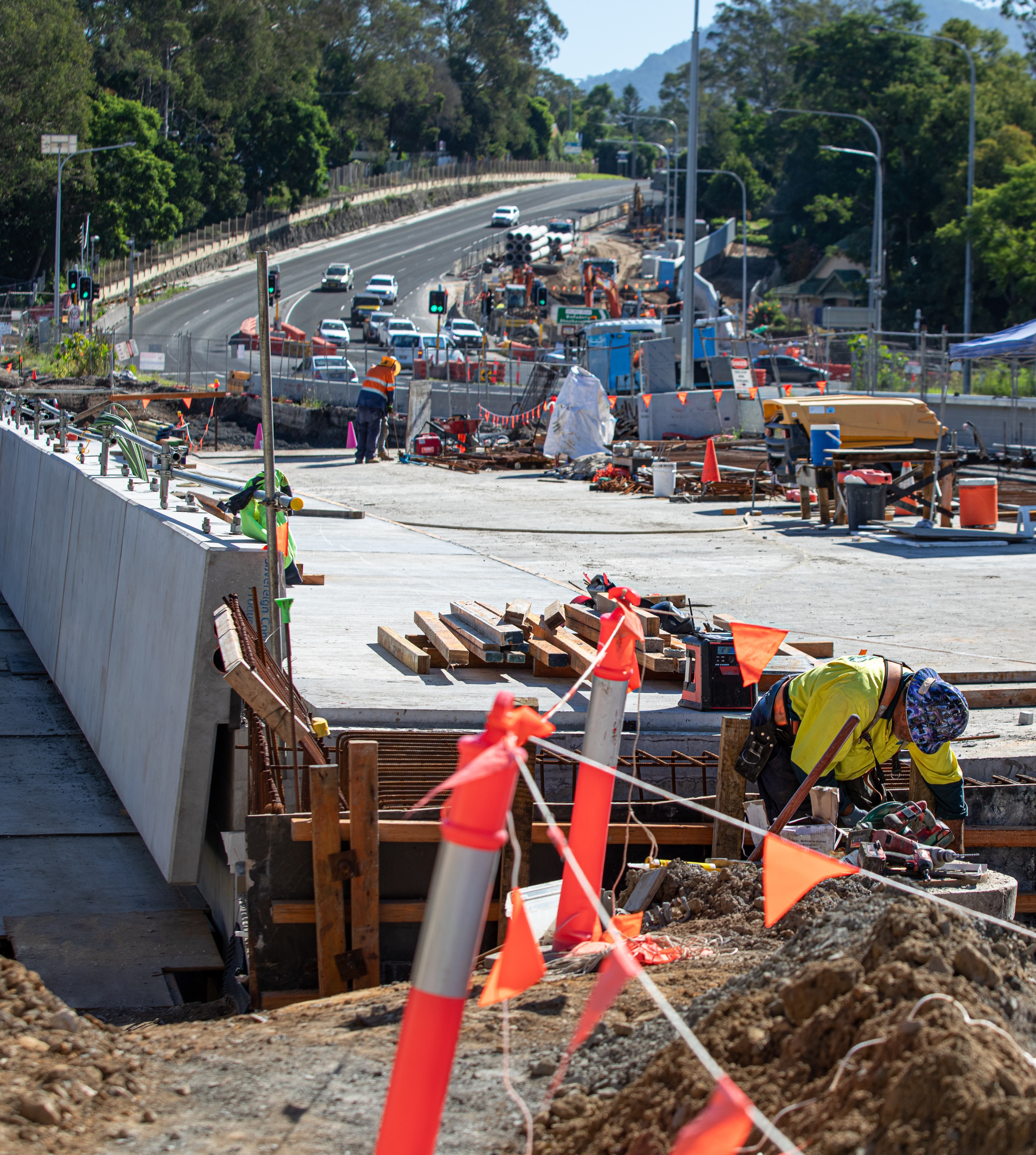 bridge construction site with trees and hill in background