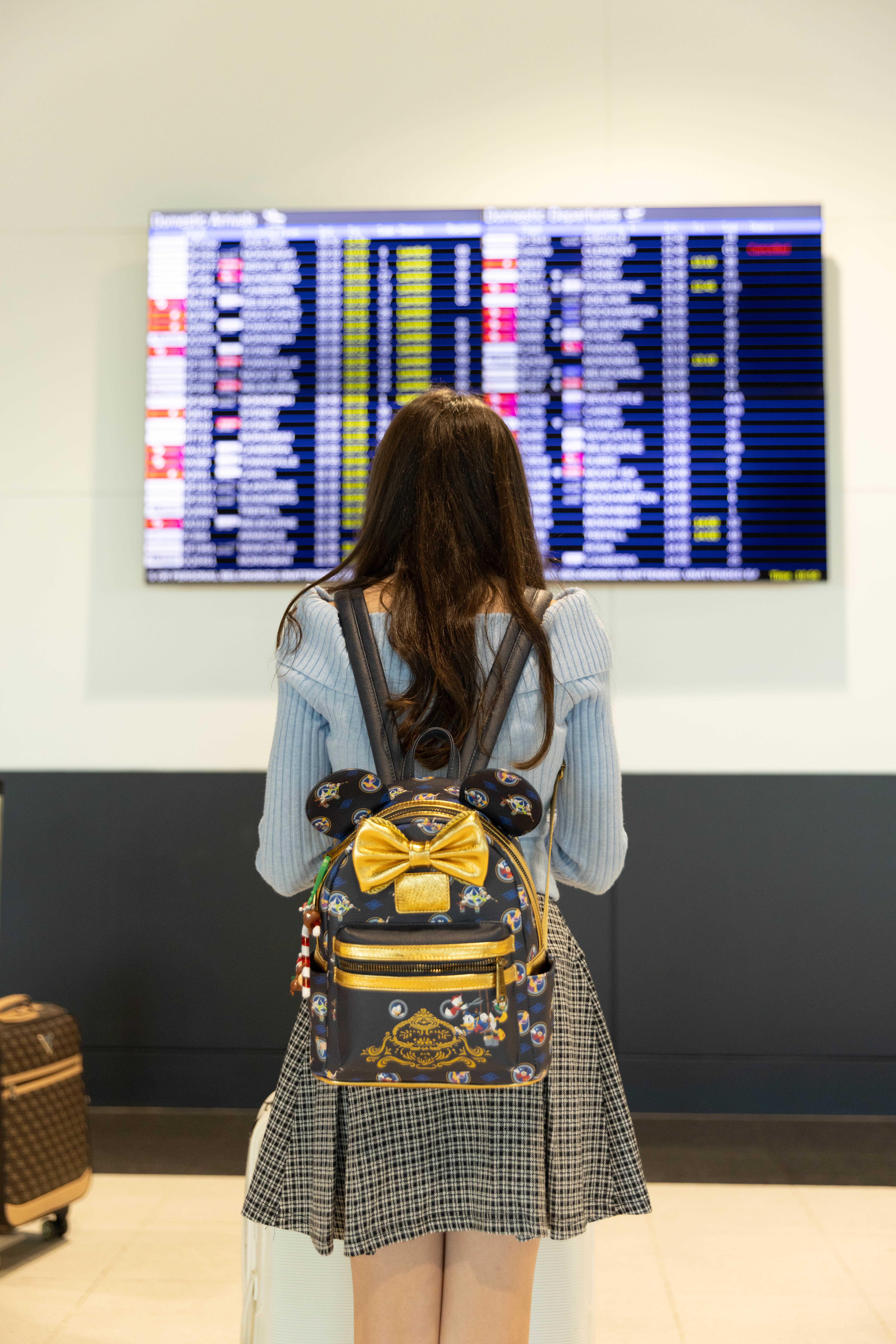 girl checking flight departure board 