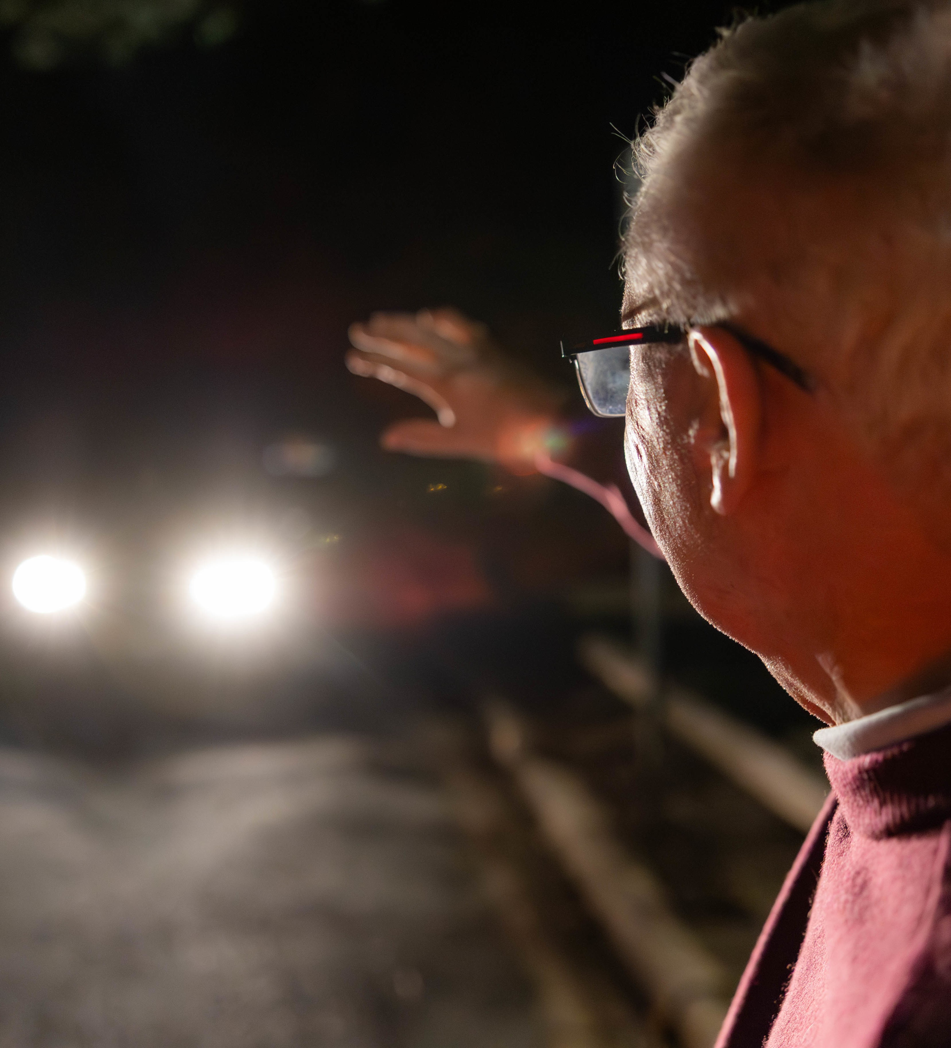 elderly pedestrian blinded by headlights on road at night